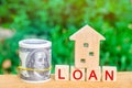 Model of the house, money and the inscription `Loan`. Buying a home in debt. Family investment in real estate and risk management