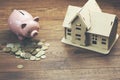 Model house and piggy bank on coins Royalty Free Stock Photo