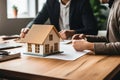 Model of the house and residential area on the table at the realtor. Signing a lease or sale agreement. Real estate offer,