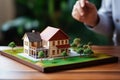 Model of the house and residential area on the table at the realtor. Signing a lease or sale agreement. Real estate offer,