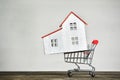 Model house and shopping cart. Buying home concept. Mortgage rent