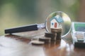 Model house on stack coin , magnifying glass searching for a new home, House searching concept with a magnifying glass Royalty Free Stock Photo