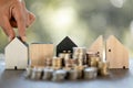 Model of house with stack coins on table on blurred background. Money saving or investing for home loan or real estate. Investment Royalty Free Stock Photo