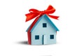 Model of a house tied with a gift ribbon isolated on a white background