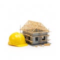 A model of a house under construction with a yellow hard hat Royalty Free Stock Photo