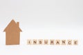 A model of house and word INSURANCE made of wooden blocks on white background. Homeowners Insurance Royalty Free Stock Photo