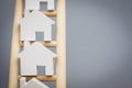 Model Houses On Rungs Of Wooden Property Ladder