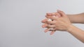 Model is interlace fingers and continue rubbing with foam hand soap on white background