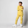 Model of a little boy in a tracksuit with sweatshirt and trousers. Portrait isolated on gray background. Male child Royalty Free Stock Photo