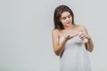 Model look is a beautiful young twin in a white terry towel. Applying a body lotion on her shoulder and smiling while Royalty Free Stock Photo