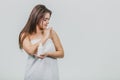 Model look is a beautiful young twin in a white terry towel. Applying a body lotion on her shoulder and smiling while Royalty Free Stock Photo