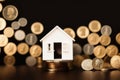 Model of miniature houses made of wood and gold coins. Generative AI