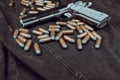 Model 1911 pistol and cartridges (.45 ACP) on a black denim background