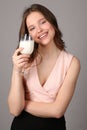 Model posing with a bocal of milk. Close up. Gray background