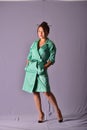 Model posing in light green raincoat standing in the studio. Retro style Royalty Free Stock Photo