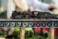 Model railroad. Old locomotive on an iron bridge. Royalty Free Stock Photo