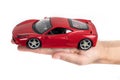 Model of a red sports car in hand on a white background Royalty Free Stock Photo