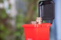 A model of a red trash can with dollar coins coming out of the lid.The Chinese characters on the trash can mean`Harmful refuse`and