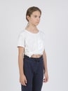 Model samples , waist high portrait , white girl 11 years old in dark pants and a white shirt on a white