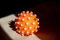 Red bright spiny ball isolated on dark background. Toy, close-up. Coronavirus model.model of the SARS-CoV-2 virus ,toy Royalty Free Stock Photo