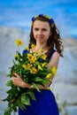 Beautiful cute girl in blue dress with bouquet of yellow Royalty Free Stock Photo