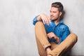 Model sitting in studio legs crossed looking way