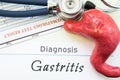 Model of stomach, blood test and stethoscope lying next to written title on paper diagnosis Gastritis. Concept photo of causes, di