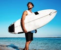 Model surfer wearing casual clothes going with surfboard on blue ocean Royalty Free Stock Photo