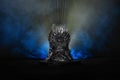 The model of throne as in Game of throne at a bright blue smoke background