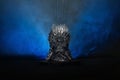 The model of throne as in Game of throne at a bright blue smoke background