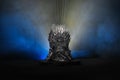 The model of throne as in Game of throne at a bright blue smoke background