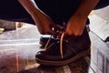 Model tiding laces of his brown color boots