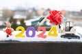 model of a toy excavator, souvenir deer, New Year 2024 numbers in the snow