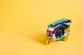 Model Toy tuk tuk isolated on yellow background. Thai traditional taxi in Bangkok Thailand. Souvenir Royalty Free Stock Photo