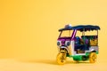 Model Toy tuk tuk isolated on yellow background. Thai traditional taxi in Bangkok Thailand. Souvenir Royalty Free Stock Photo