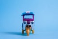 Model Toy tuk tuk isolated on blue background. Thai traditional taxi in Bangkok Thailand. Souvenir Royalty Free Stock Photo