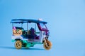 Model Toy tuk tuk isolated on blue background. Thai traditional taxi in Bangkok Thailand. Souvenir Royalty Free Stock Photo