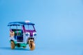 Model Toy tuk tuk isolated on blue background. Thai traditional taxi in Bangkok Thailand. Souvenir Royalty Free Stock Photo