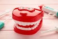 Model toys teeth with dentist instrument on pink background