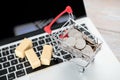 A model of a trolley full of dollar coins and cargo on a laptop