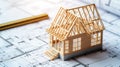 Under construction wooden frame house model on blueprints with copy space Royalty Free Stock Photo