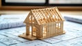 Under construction wooden frame house model on blueprints with copy space Royalty Free Stock Photo