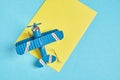 Model of vintage metal plane and yellow concert on blue background, air mail concept, long distance mail sending Royalty Free Stock Photo