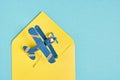 Model of vintage metal plane and yellow concert on blue background, air mail concept, long distance mail sending Royalty Free Stock Photo