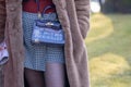 Model wearing a black and white checked mini skirt and a handbag