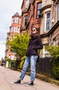 Model wearing blue skinny jeans, black sneakers and sunglasses