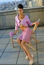 Model wearing couture pink suit posing on the rooftop