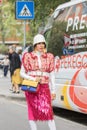 Model wearing a pair of white boots, a pink skirt, a white hat and a multicolored Gucci handbag