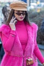 Model wears a fuchsia turtleneck sweater, a fuchsia jacket and a pair of python pants