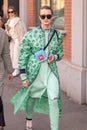 Model wears a green dress and a fancy green overcoat